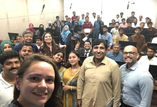 Students, Team EducationUSA, and officers from the U.S. consulate in Karachi pose for a picture at the University of Larkana outreach